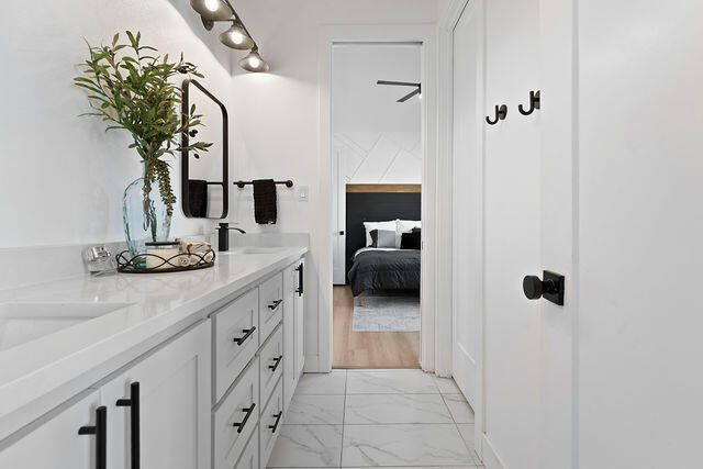 823 13th Street Wolfforth, TX 79382 - Photo 23 of 32 a en suite bathroom with a granite countertop sink and a mirror