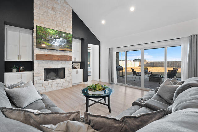 823 13th Street Wolfforth, TX 79382 - Photo 5 of 32 a living room with furniture a fireplace and a floor to ceiling window