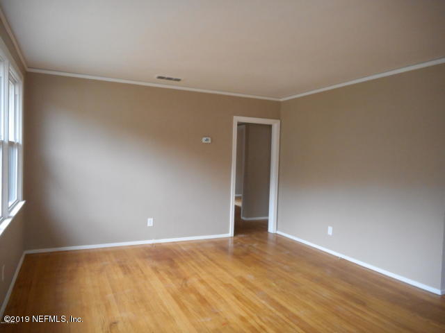 1774 Mayfair Road Jacksonville, FL 32207 - Photo 5 of 8 a view of an empty room with wooden floor and a window