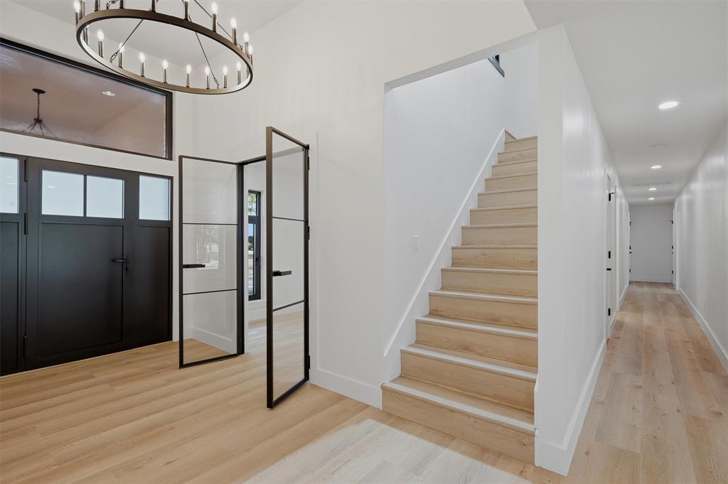 410 Arkansas Road Sadler, TX 76264 - Photo 6 of 40 Entryway featuring a large chandelier, double black entry doors with upper window panels, and wood-finish flooring