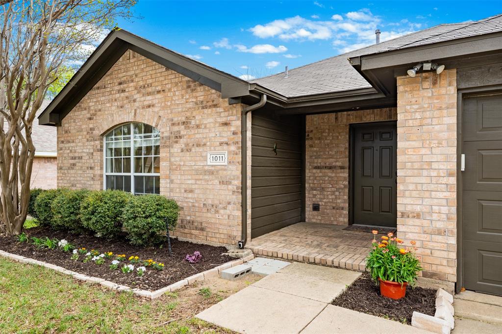 1011 Ridgecrest Drive McKinney, TX 75069 - Photo 6 of 31 Brick exterior with an arched window, a covered entryway, and an attached garage
