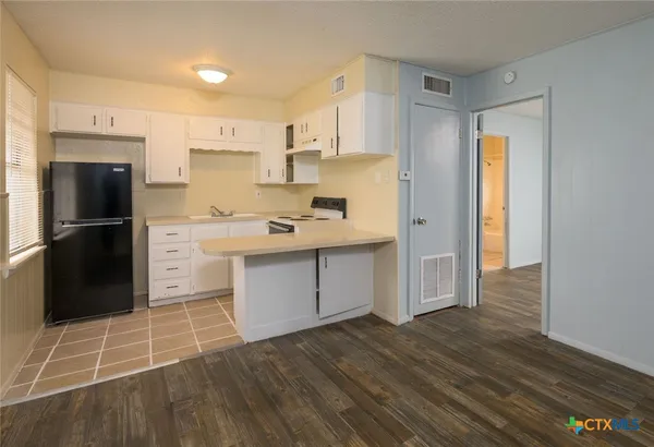 a kitchen with a refrigerator and a stove top oven