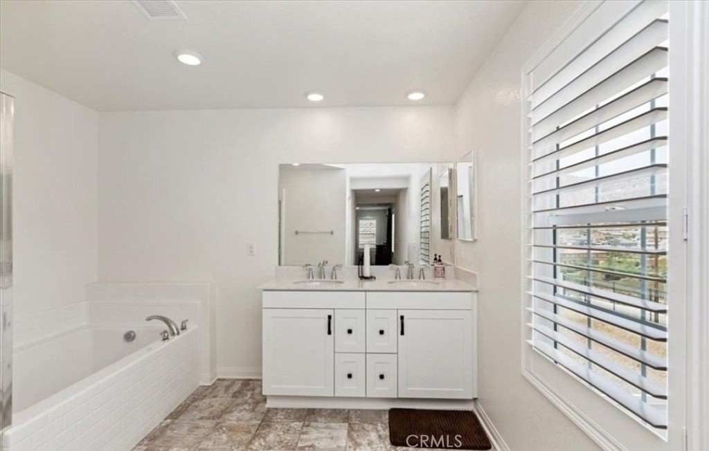 21288 Telegraph Road Riverside, CA 92507 - Photo 14 of 23 a spacious bathroom with a sink a large mirror and a bathtub