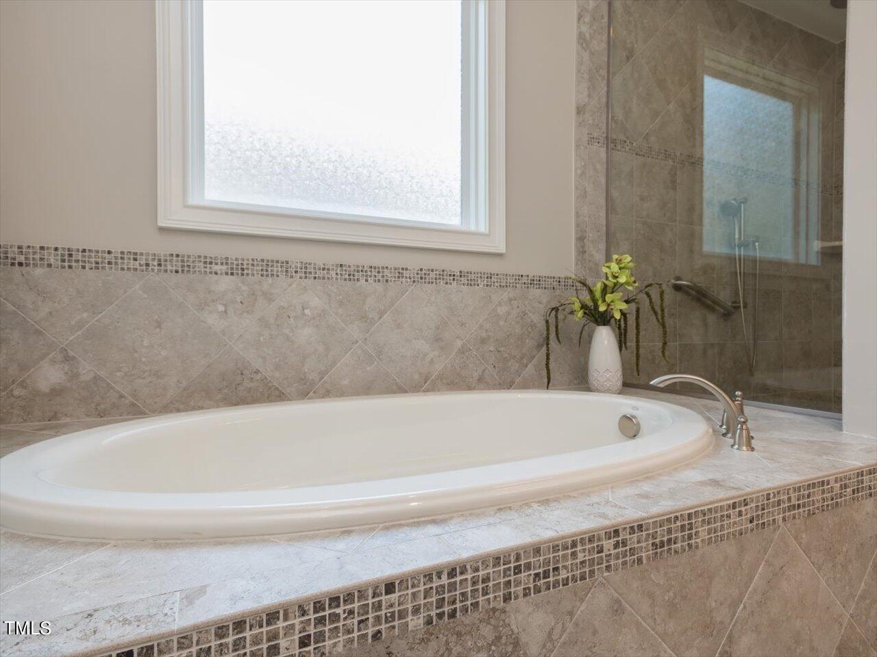 3105 Colmar Manor Drive Cary, NC 27519 - Photo 23 of 61 a bathroom with bathtub and window