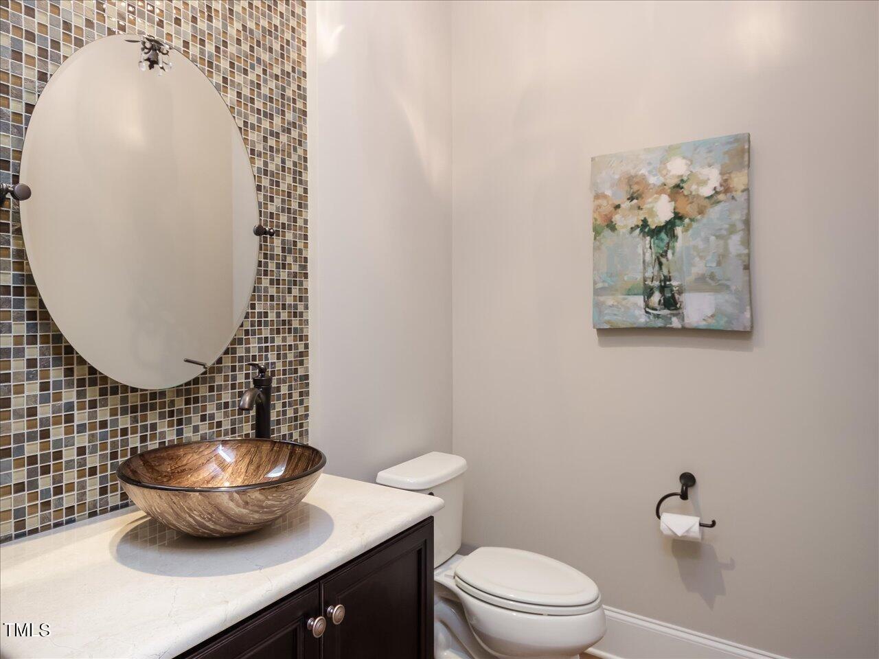 3105 Colmar Manor Drive Cary, NC 27519 - Photo 28 of 61 a bathroom with a toilet a sink and mirror
