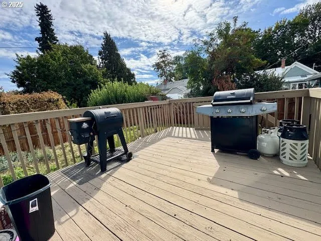 a view of a deck with wooden floor and barbeque oven