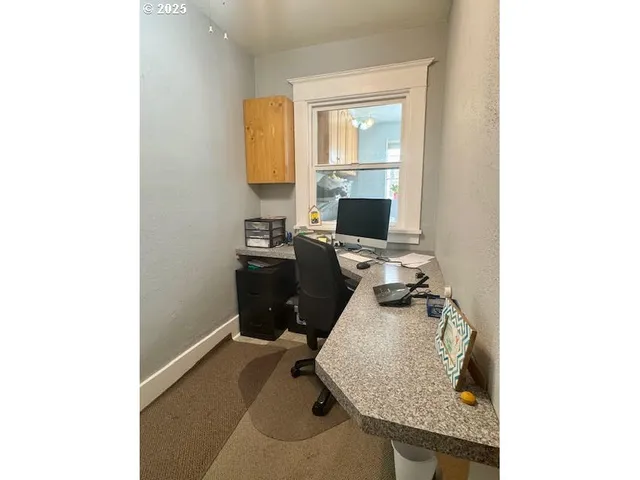 a view of a workspace with furniture and a window