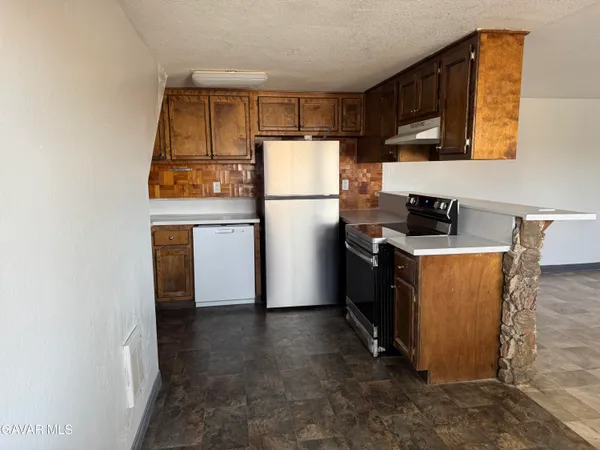 a kitchen with a refrigerator and a stove top oven