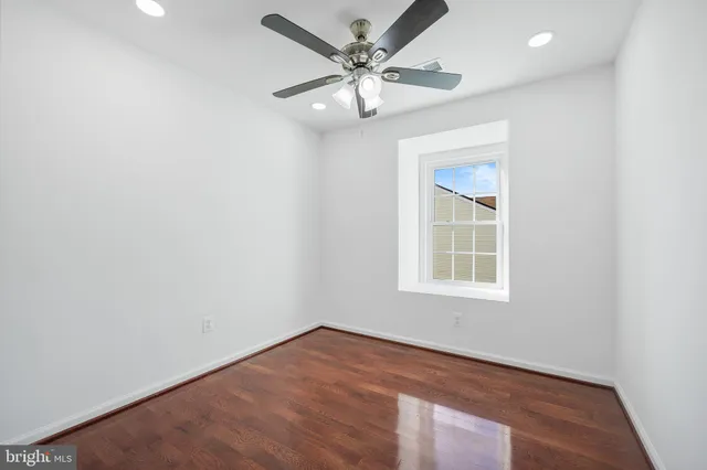 an empty room with a window and a fan