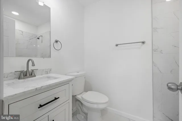 a bathroom with a sink toilet and a mirror