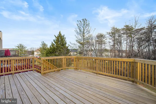 a view of deck with wooden floor and fence with a bench