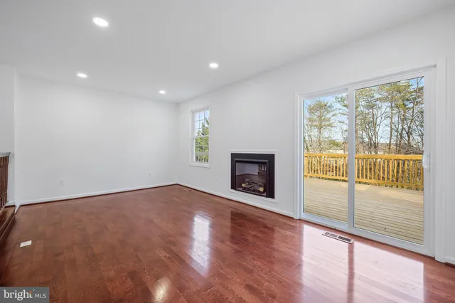 an empty room with wooden floor and fireplace