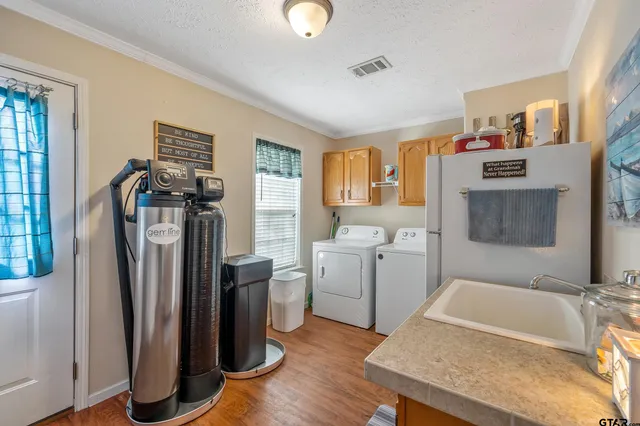 a view of a kitchen with fridge and wooden floor