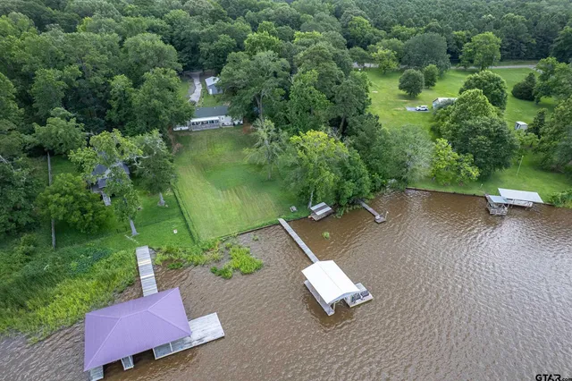 an aerial view of a house with a yard and lake view