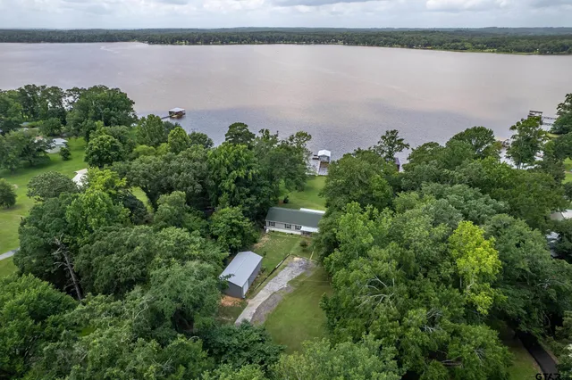 a aerial view of a house with a yard and lake view