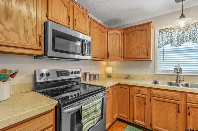 a kitchen with stainless steel appliances granite countertop a sink stove and microwave