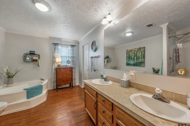 a spacious bathroom with a double vanity sink a mirror and a bathtub