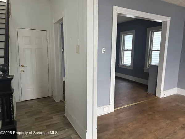 a view of a hallway with a room and front door