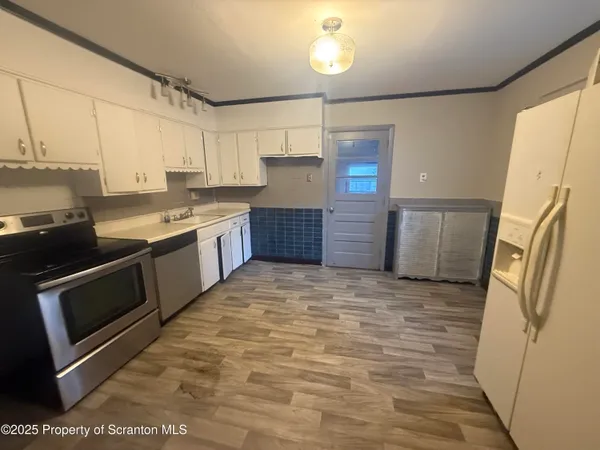 a large kitchen with a stove a refrigerator and a sink