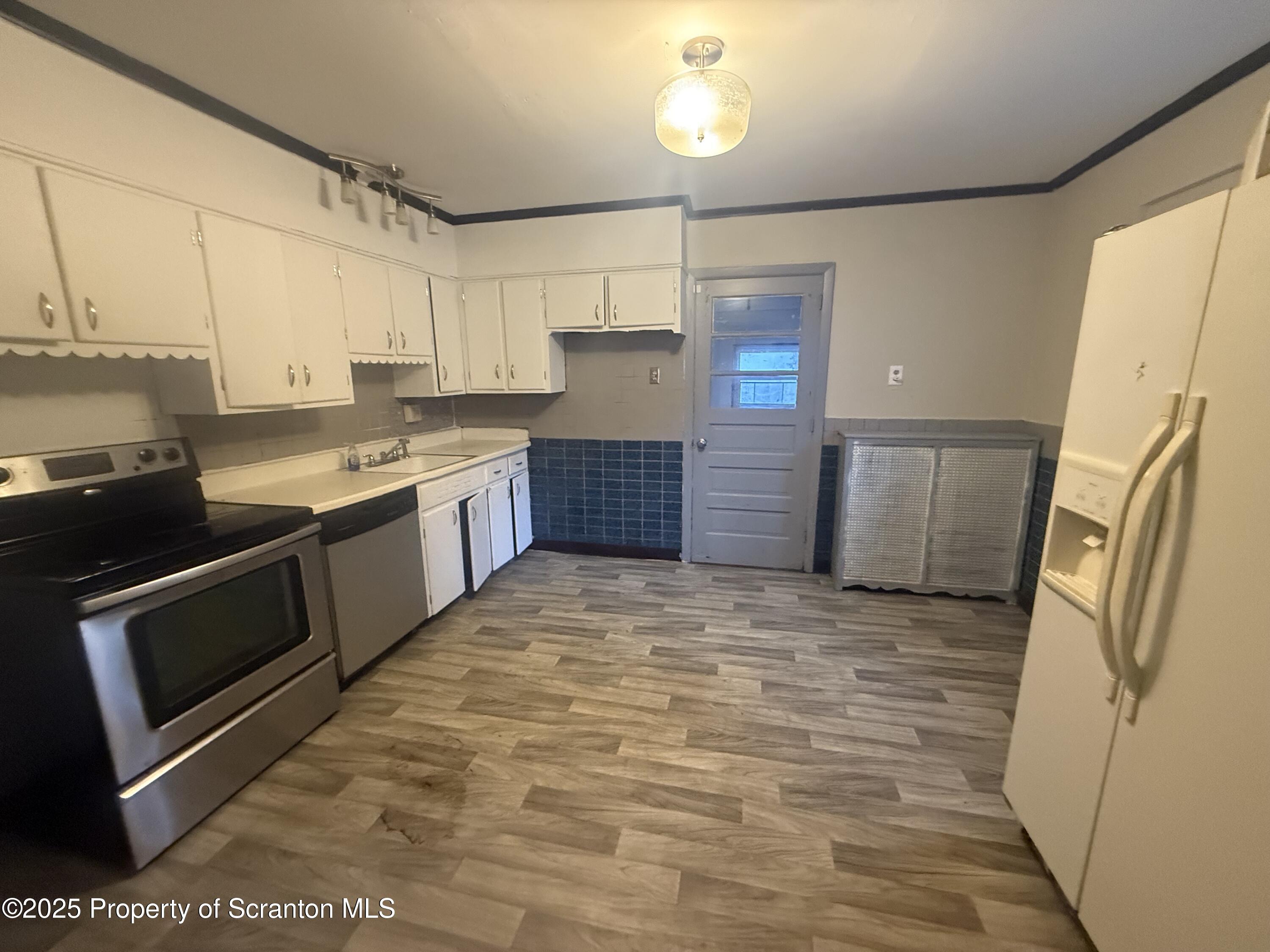 319 North Sumner Avenue Scranton, PA 18504 - Photo 6 of 13 a large kitchen with a stove a refrigerator and a sink