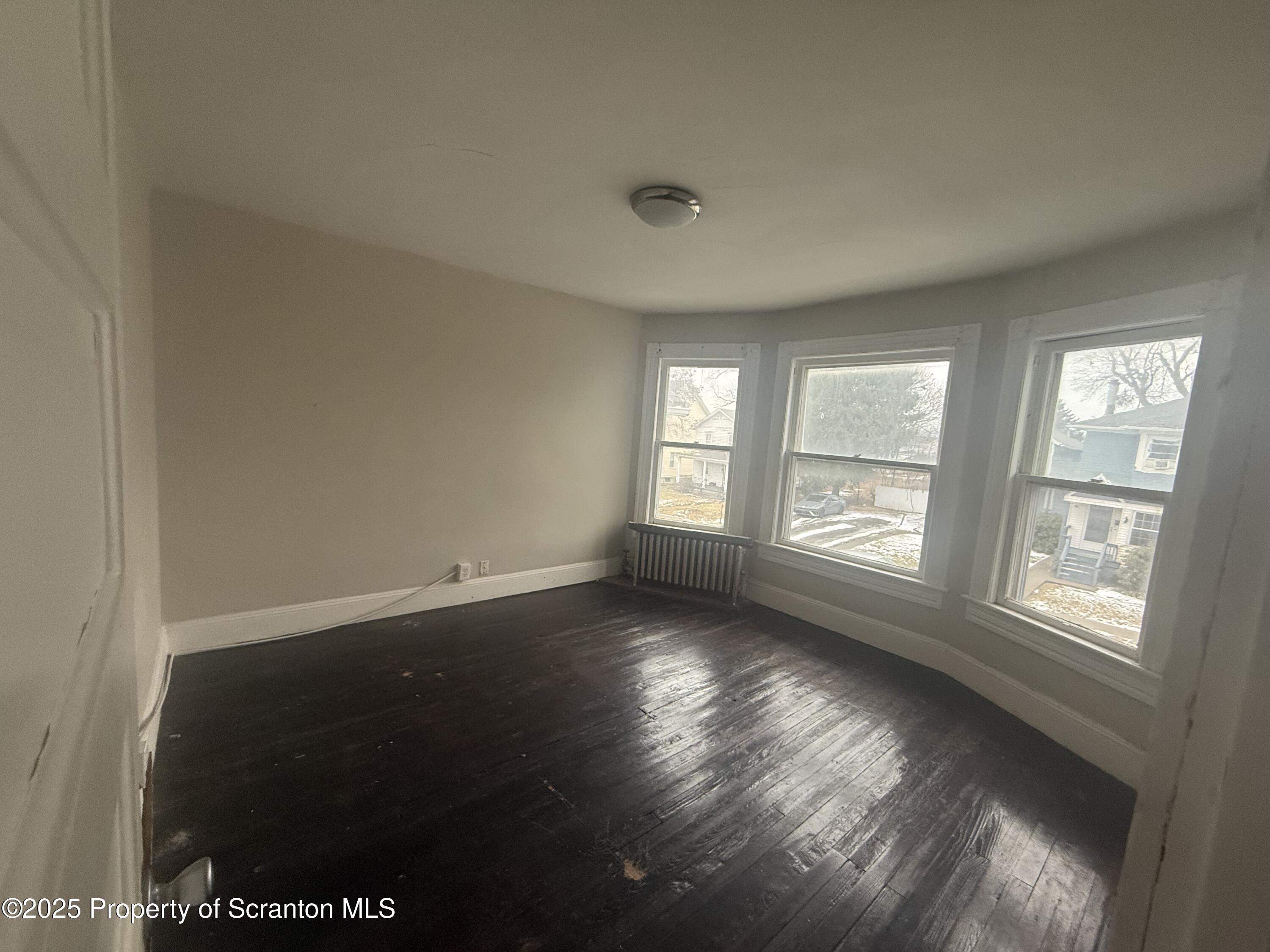 319 North Sumner Avenue Scranton, PA 18504 - Photo 8 of 13 an empty room with wooden floor and windows