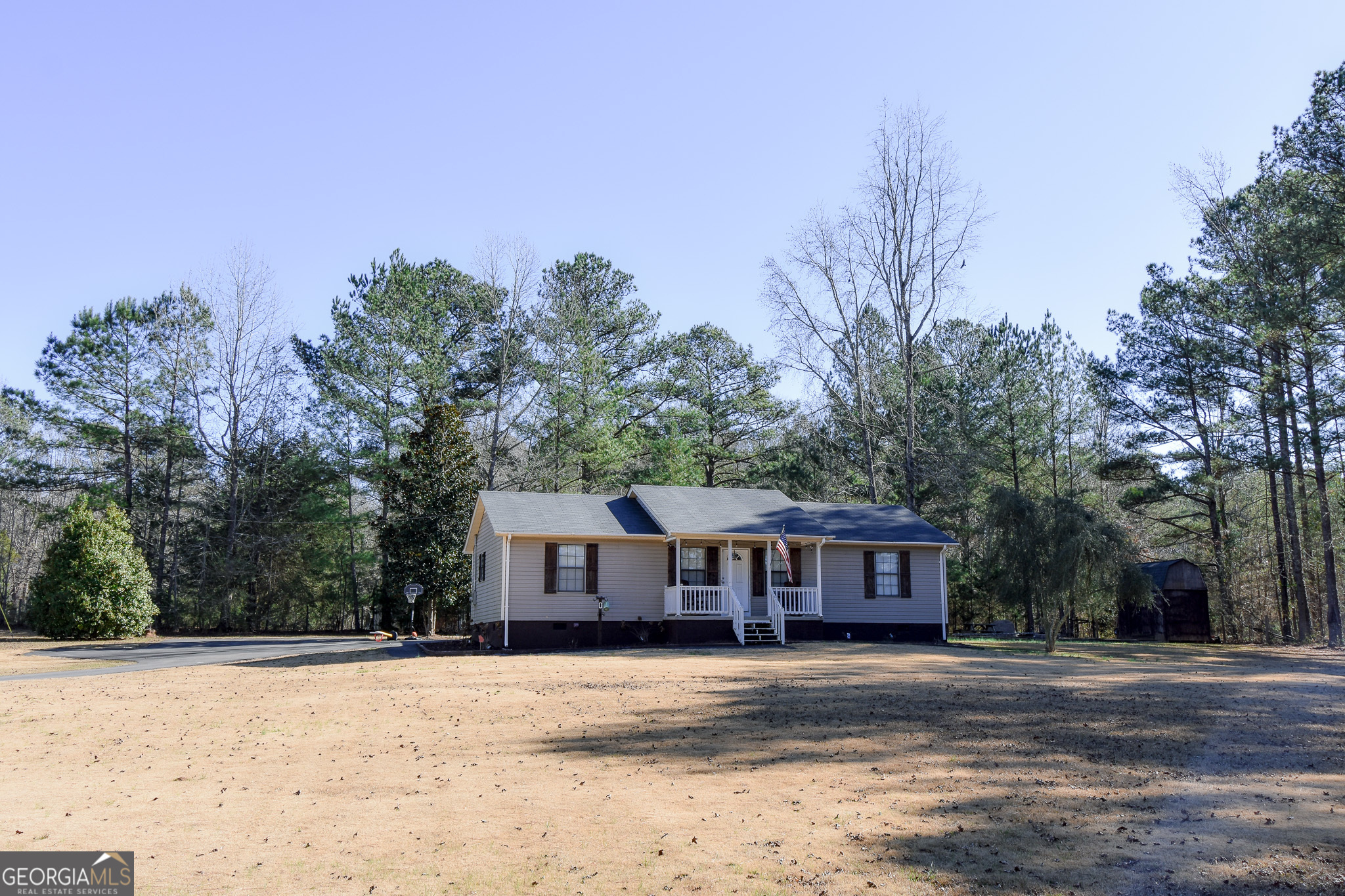 a front view of a house with a yard and trees