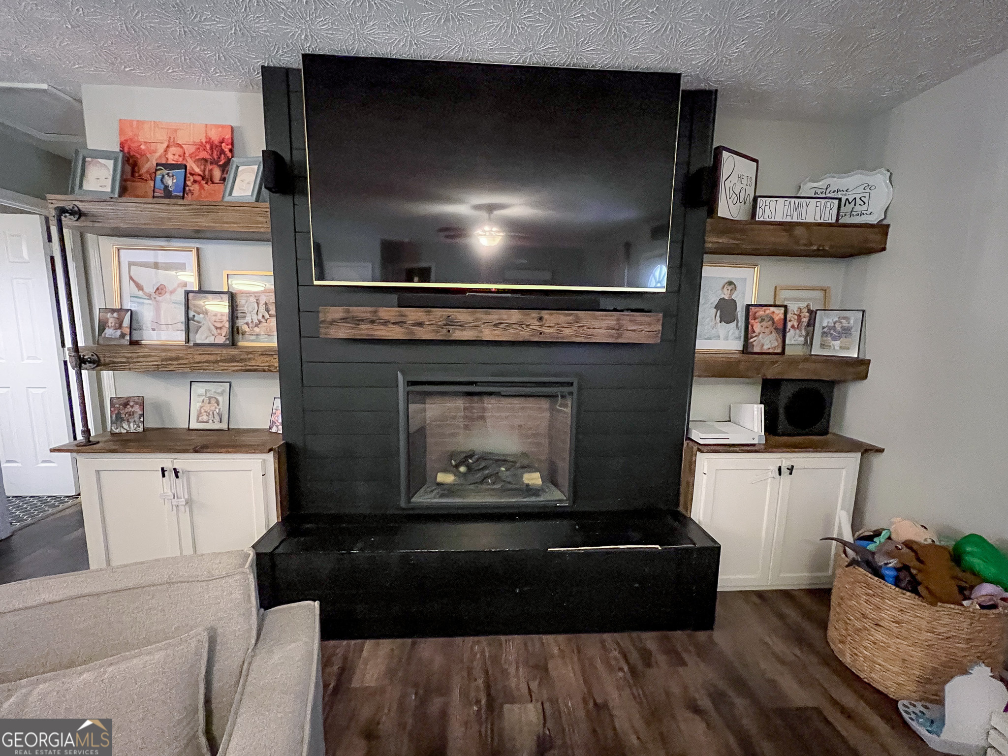 741 Howell Road Zebulon, GA 30295 - Photo 38 of 79 a living room with furniture a flat screen tv and a fireplace