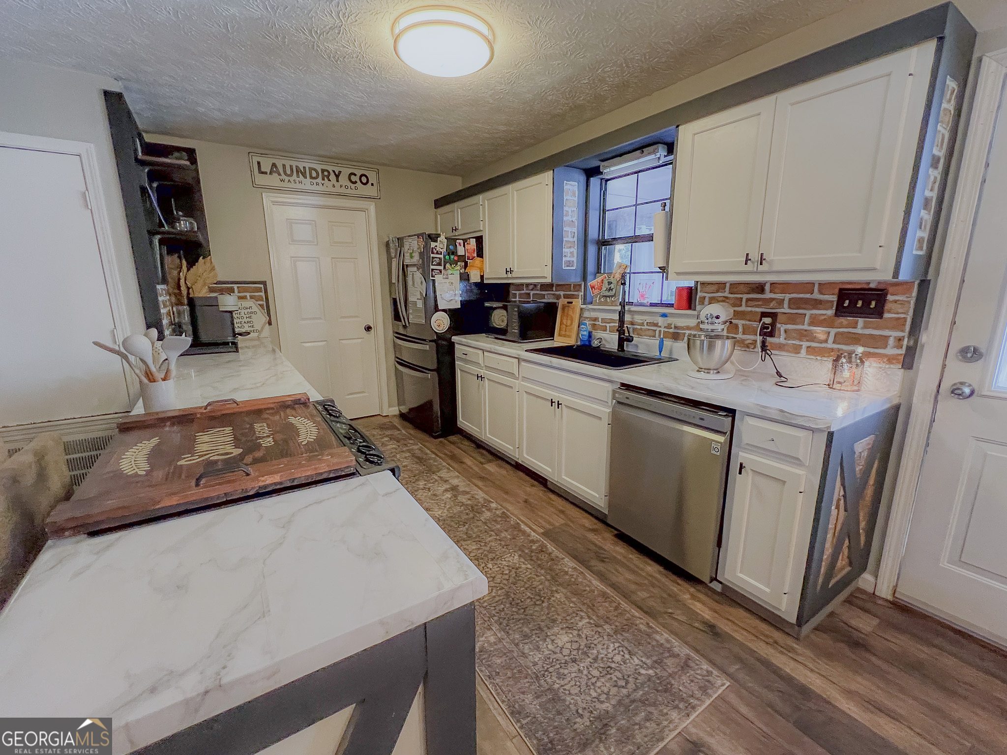 741 Howell Road Zebulon, GA 30295 - Photo 62 of 79 a kitchen with sink a microwave and cabinets