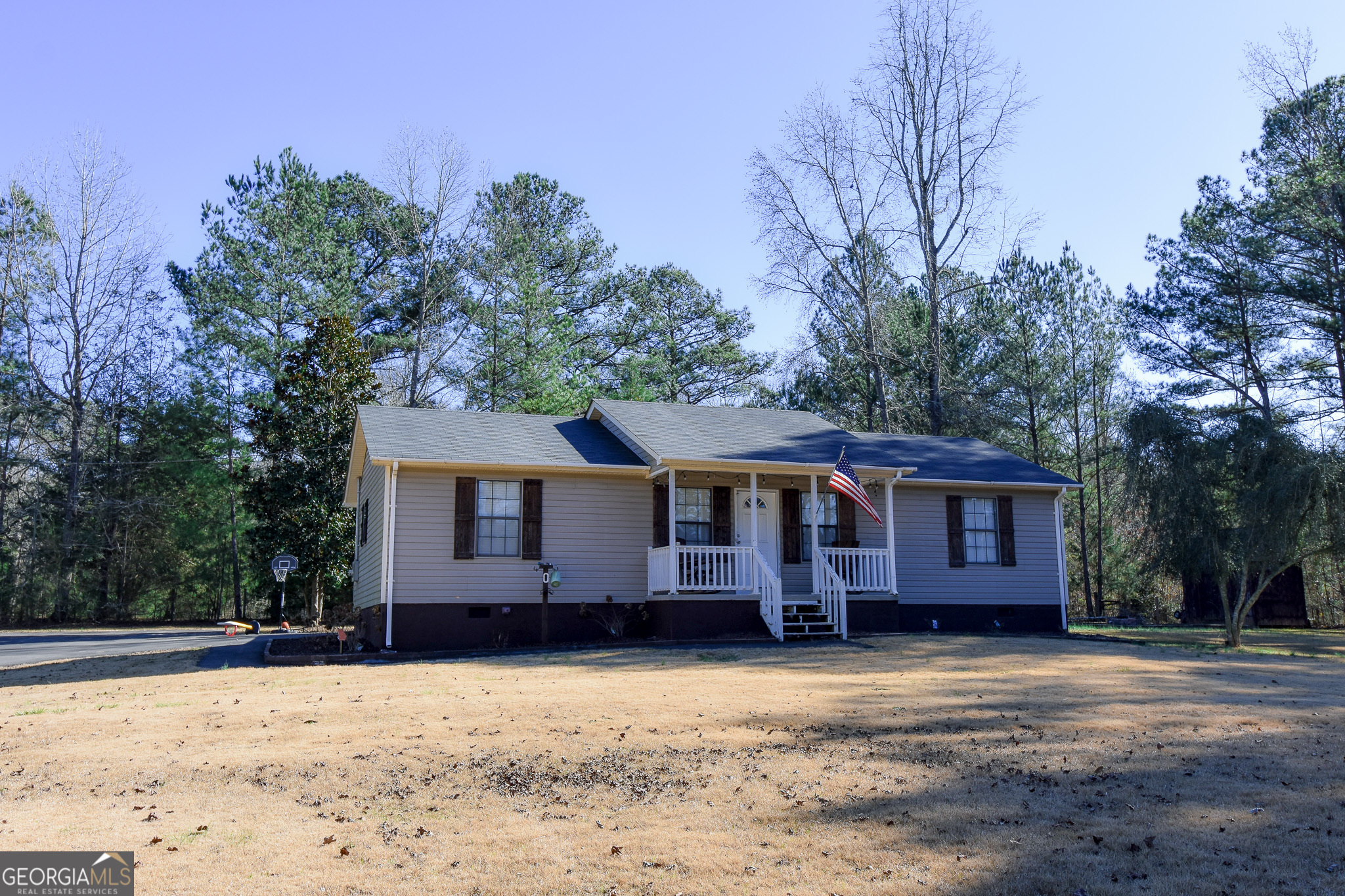 741 Howell Road Zebulon, GA 30295 - Photo 8 of 79 a front view of a house with a yard covered with trees