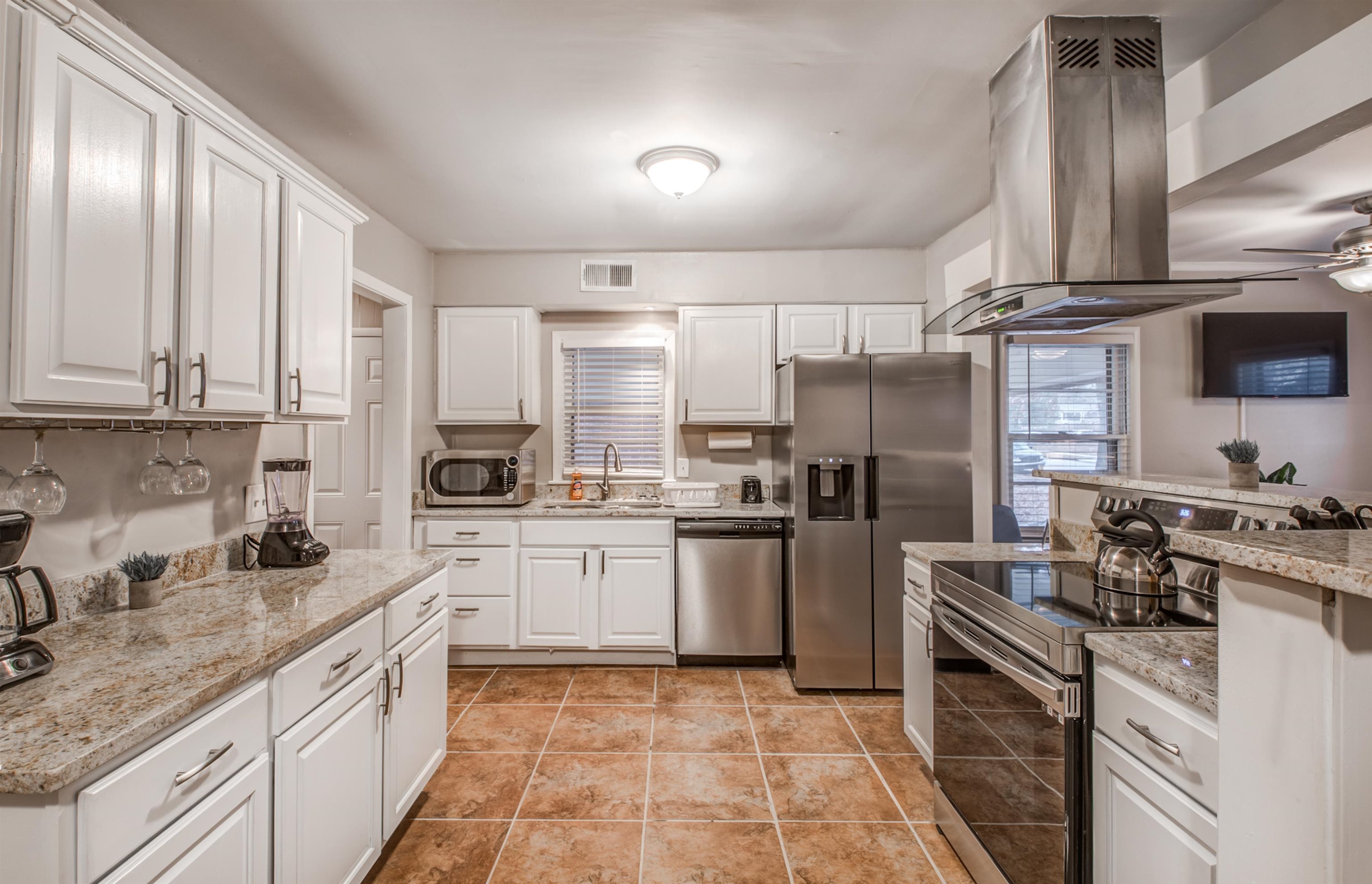 4850 Flamingo Road Memphis, TN 38117 - Photo 20 of 40 Kitchen with stainless steel appliances, island range hood, white cabinetry, and ceiling fan