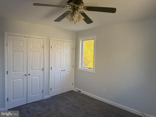 an empty room with windows and closet