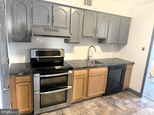 a kitchen with stainless steel appliances granite countertop a sink stove and cabinets