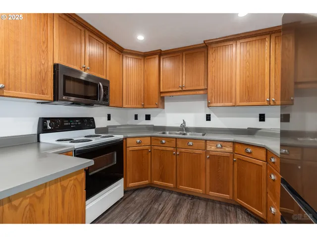 a kitchen with stainless steel appliances granite countertop wooden cabinets a stove top oven a sink and dishwasher