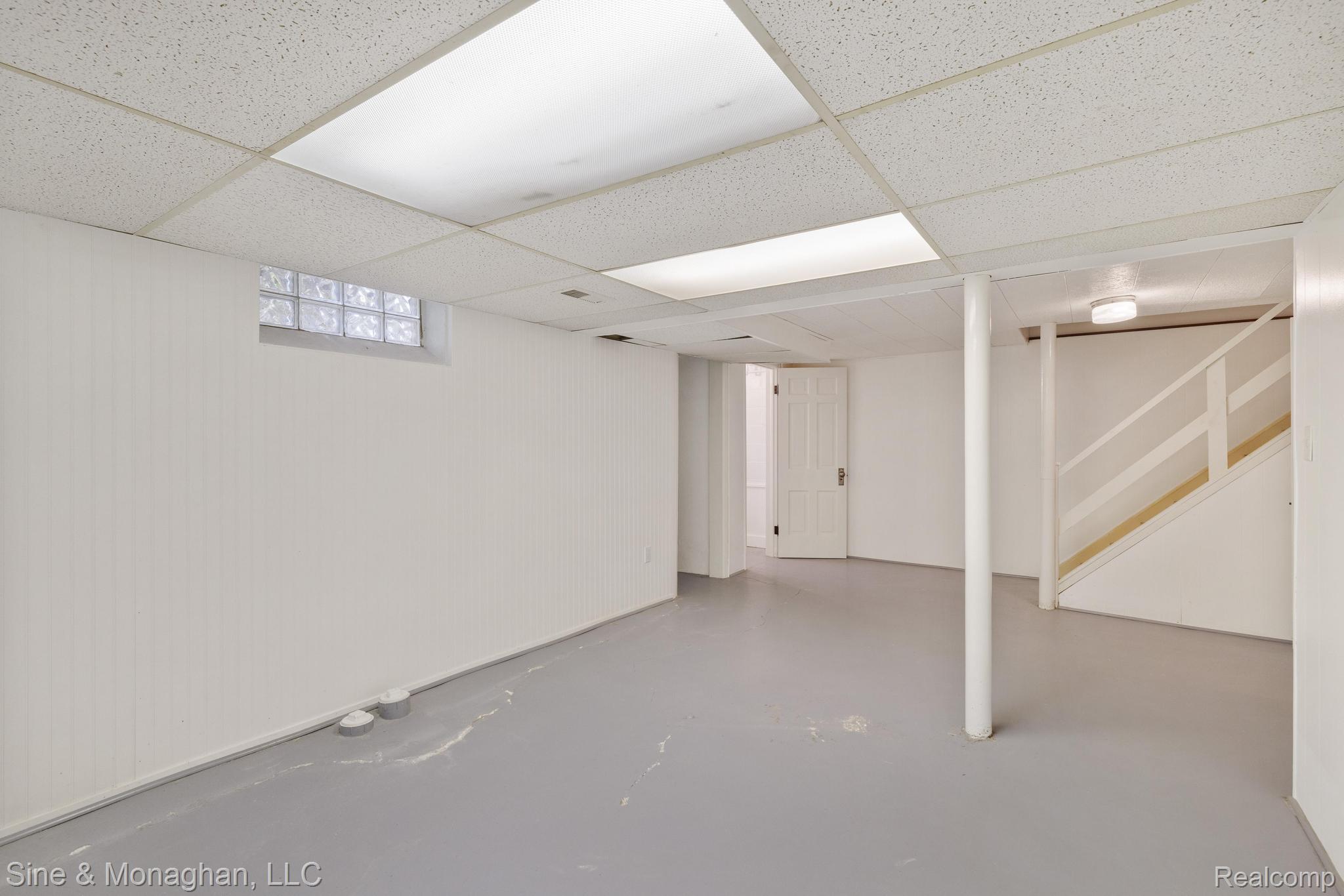 679 Neff Road Grosse Pointe, MI 48230 - Photo 35 of 78 Finished basement featuring painted concrete flooring, suspended ceiling with integrated lighting, glass block window, and exposed support columns