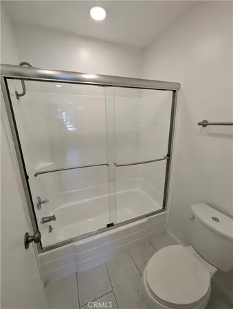 a bathroom with a white toilet and a shower