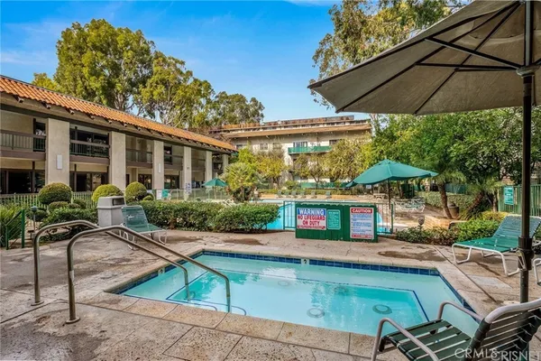 a view of a tennis ground with large trees