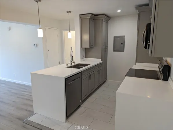 a kitchen with stainless steel appliances granite countertop a sink a refrigerator and a stove