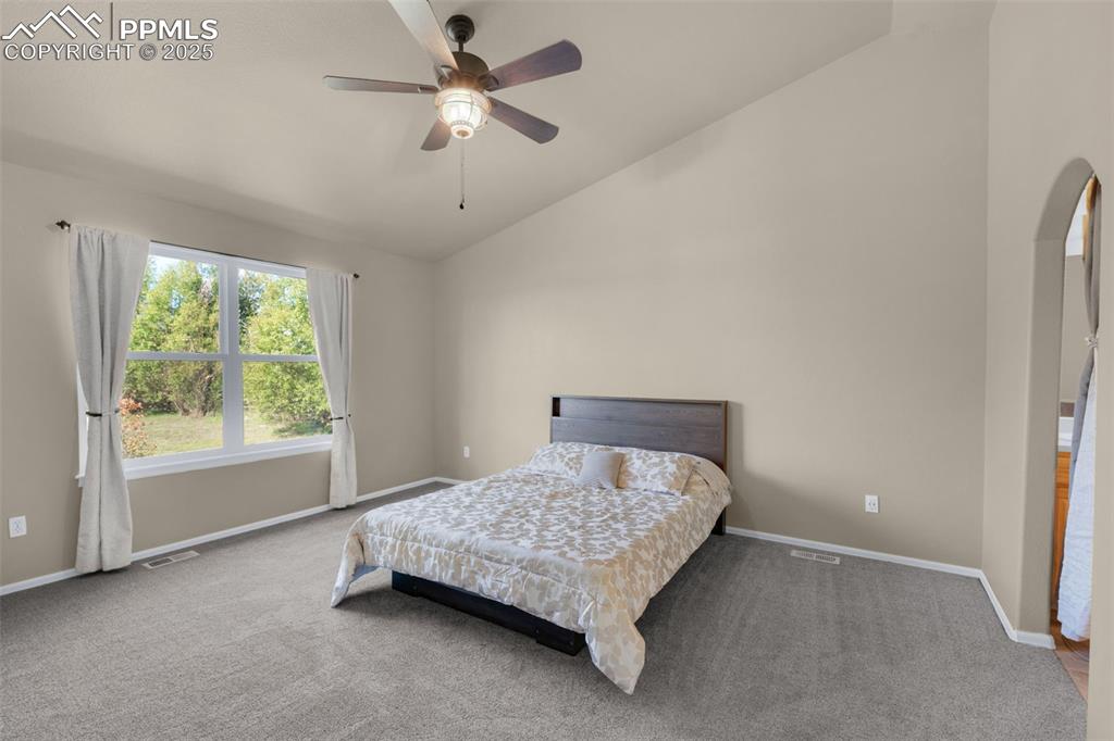 8534 Saddleman Road Peyton, CO 80831 - Photo 8 of 25 a bedroom with a bed chandelier and a window