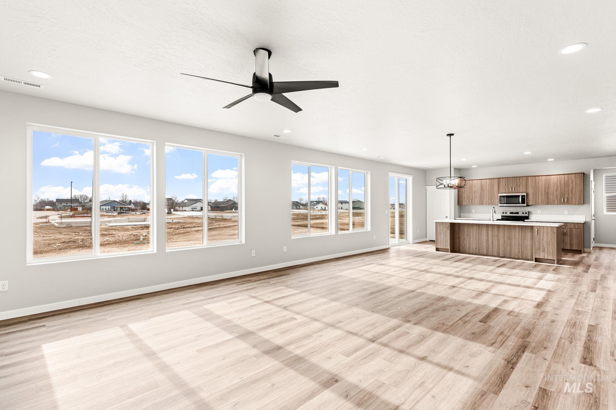 448 Merlin Court Middleton, ID 83644 - Photo 10 of 29 Open-concept living space with wood-finish flooring, a contemporary ceiling fan, and recessed lighting