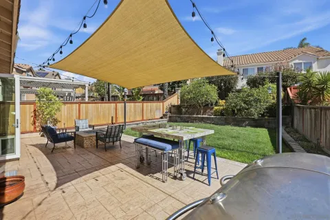 a view of a patio with table and chairs under an umbrella