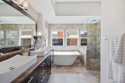 a spacious bathroom with a double vanity sink a mirror and a bathtub