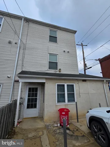 a front view of a house with parking space and a car parked in garage