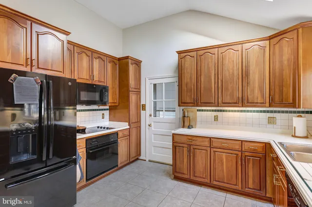 a kitchen with stainless steel appliances granite countertop a refrigerator and a stove top oven