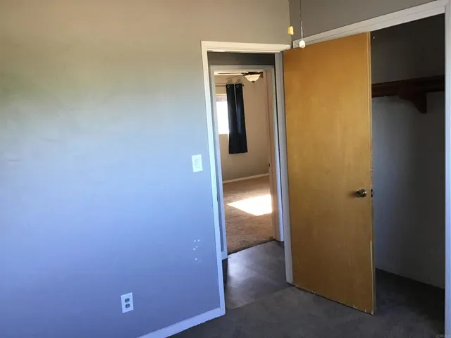 an empty room with wooden floor and a bathroom