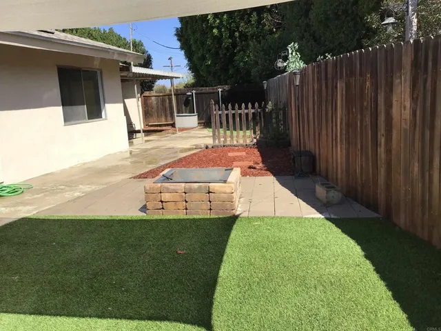 a view of a backyard with wooden fence