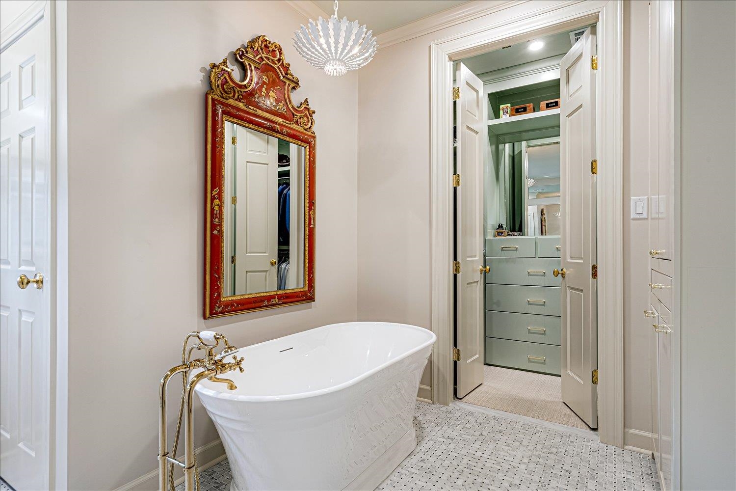 Bathroom with a soaking tub, crown molding, and a chandelier