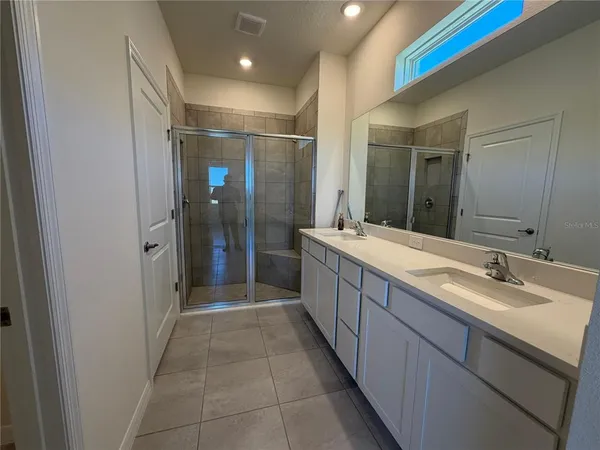 a bathroom with a double vanity sink and mirror