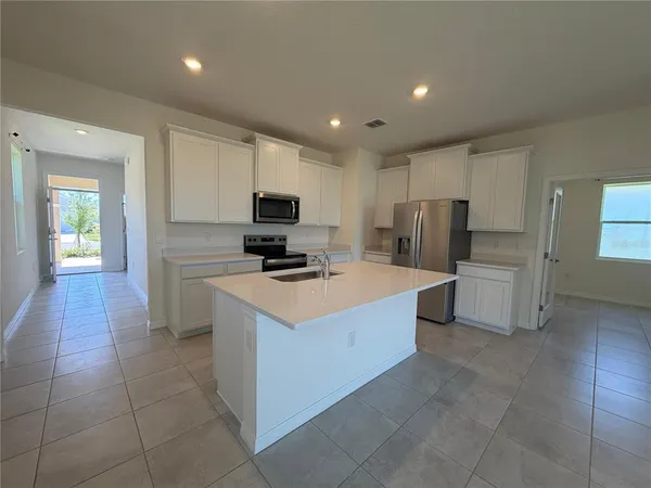 a kitchen with stainless steel appliances a refrigerator sink and microwave