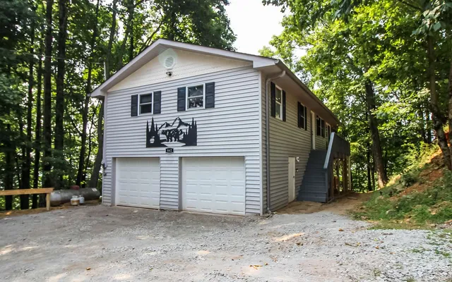 a view of a small house with a yard and garage