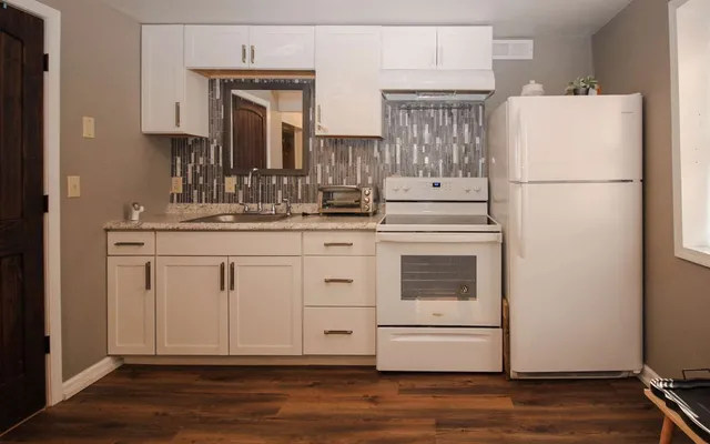 a kitchen with stainless steel appliances granite countertop a refrigerator sink and stove